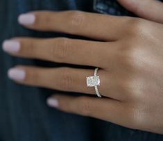 a woman's hand with a diamond ring on it