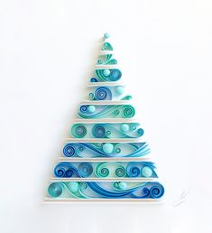 a glass christmas tree with blue swirls on it's sides and white background