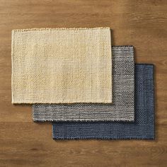 three different colors of fabric on top of a wooden table