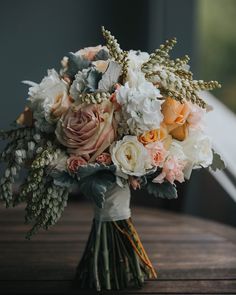 a bouquet of flowers sitting on top of a wooden table