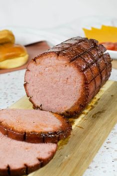 smoked bologna with a hot honey glaze on a cutting board next to sliced bananas