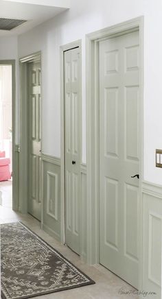 a living room with white walls and green doors