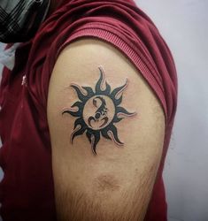 a man with a sun and moon tattoo on his arm