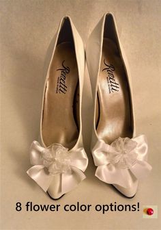 two pairs of white shoes with bows on them