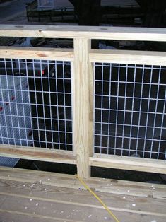 a close up of a metal gate on a wooden floor with wire mesh covering it