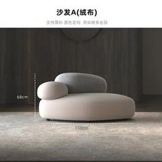 a white couch sitting on top of a floor next to a wooden wall in an empty room