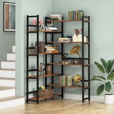 a bookshelf in the corner of a room with stairs leading up to it