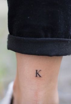 a person with a small k tattoo on their leg and the letter k behind them