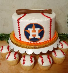 a baseball themed cake and cupcakes on a table