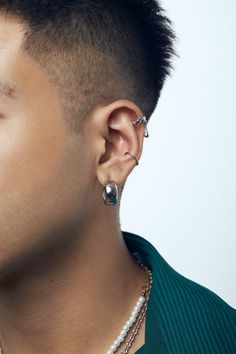 a close up of a person with ear piercings and a necklace on his neck