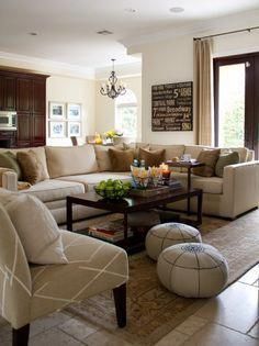 a living room filled with lots of furniture and a chandelier hanging from the ceiling