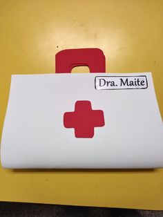 a white box with a red cross sticker on the lid that says dr maite