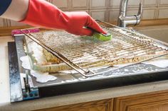 a person in red gloves is cooking food on a grill