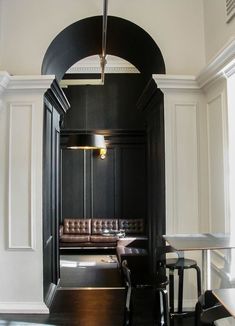 the interior of a restaurant with white walls and black wood paneling on the wall