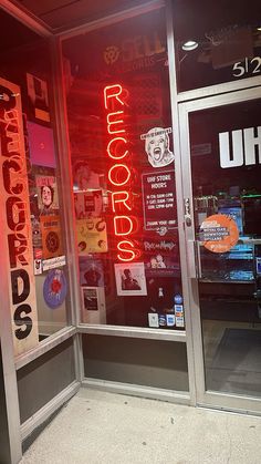 an image of a store front with neon signs on the glass door and window display