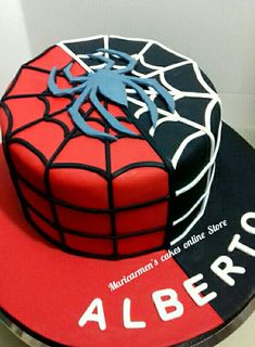 a spiderman themed cake on top of a red and black plate with white lettering