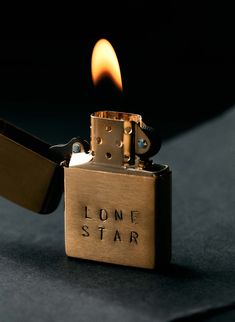 a lighter with the word lone star engraved on it's side, lit up