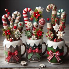 three mugs filled with candy canes and christmas decorations