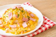 ham and cheese omelet on a white plate with a red checkered napkin