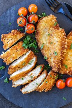 some food is laying out on a plate with tomatoes and other foods around it,