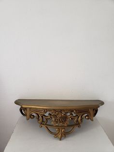 an ornate wooden shelf sitting on top of a white table