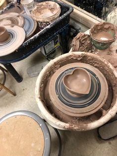 pottery being made in a potter's wheel with other pots and pans on the table