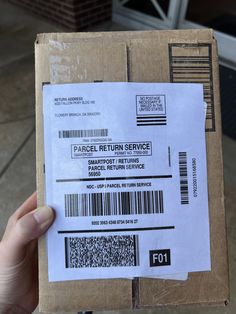 a person is holding up a box that has a barcode on the front and back of it