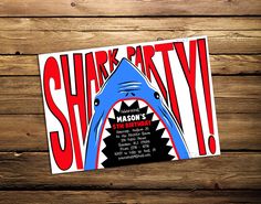 the shark party flyer is displayed on a wooden table