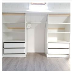 an empty room with white shelves and drawers