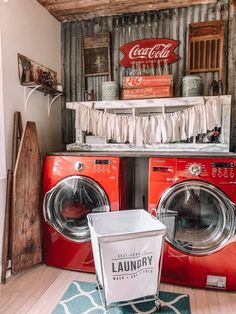 a red washer and dryer sitting next to each other in front of a coca cola sign