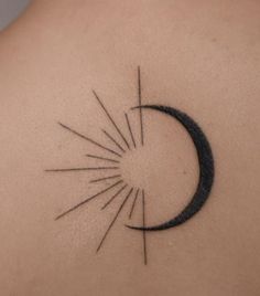 a tattoo on the back of a woman's shoulder with a sun and star