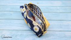 a blue and yellow flowered purse sitting on top of a wooden table