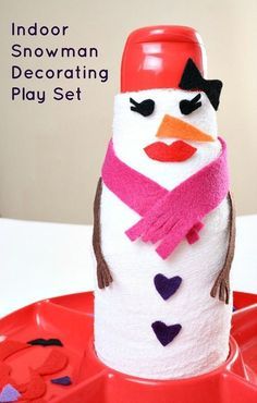 a toilet paper roll snowman sitting on top of a red tray