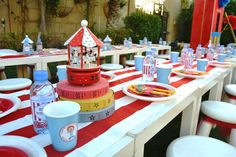 a table set up with plates, cups and napkins for an outdoor birthday party