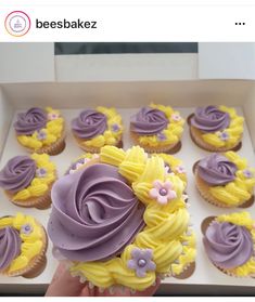 cupcakes with purple frosting and yellow icing in the shape of flowers