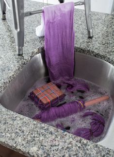 a purple towel sitting in a sink filled with water