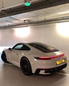 a white sports car parked in a parking garage