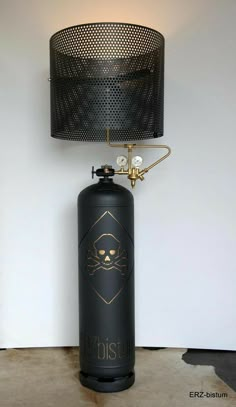 a black propane cylinder with a skull and crossbones on it next to a lamp