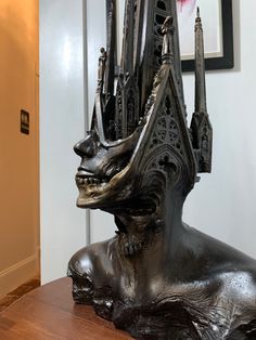 a bronze statue sitting on top of a wooden table