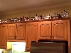 a kitchen with wooden cabinets and lots of magnets on top of the cupboards