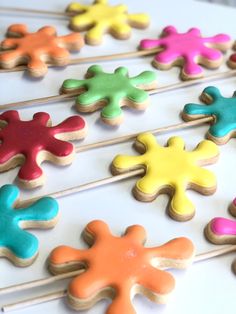 colorful cookies are arranged on toothpicks in the shape of cross - shaped stars