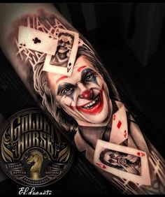 a man's arm with a joker tattoo on it and playing cards coming out of his face