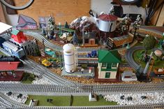 a toy train set with buildings and trees