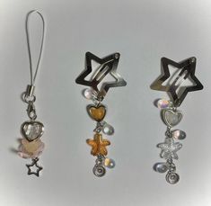 three pairs of earrings with charms attached to them