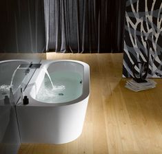 a white bath tub sitting on top of a wooden floor