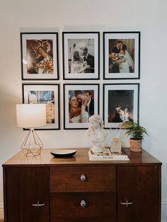 a dresser with pictures on the wall above it