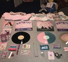 there are many items on the table that include cds, t - shirts and other things