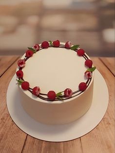 a white cake topped with fresh strawberries on top of a wooden table