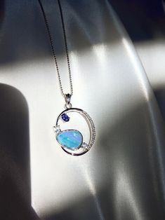 Metal: Pure .925 sterling silver Gemstone: Natural Australian boulder opal doublet with beautiful play-of-color, iolite, aquamarine, and white sapphires. Natural color, not treated. Total weight: 7.7g Dimensions: Pendant Height: 1.75 in, Width: 1 in, Depth: 1/8in Chain Length: 15.5 in This opal necklace can ship out the next day after purchase via DHL.  **INCLUDED WITH PURCHASE** ・CERTIFICATE | Every piece of BOÎTE LAQUE fine jewelry includes an individually prepared certificate of authenticity that states the spices,quality and characteristics of your piece. ・LUXURIOUS PACKAGING | We view every jewelry pieces from BOITE LAQUE as fine art for presenting and safekeeping. Our elegant presentation boxes and pouches beautifully showcase and protect your jewelry. ・CARE KIT | You will receive a White Gold Opal Jewelry With Birthstone, Tanzanite Gemstone Round Pendant, Tanzanite Gemstone Round Pendant Jewelry, Elegant Multi-stone Opal Gemstones, Exquisite Blue Cabochon Jewelry, Luxury Hallmarked Opal Jewelry, Opal Multi-stone Fine Jewelry, Multi-stone Opal Fine Jewelry, Fine Jewelry Multi-stone Opal Jewelry