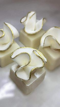 three pieces of white soap with gold decoration